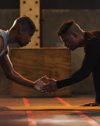 Two people facing each other in a gym